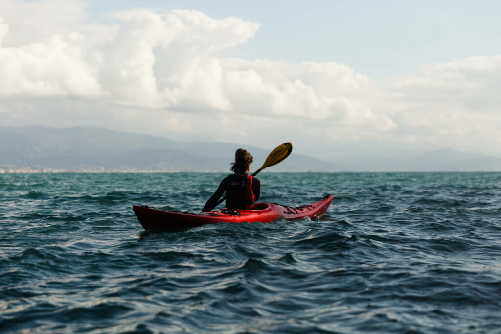 Alessandra paddles through the vast, deep sea during an action, together with the CRABS team. Photo by Tommaso Orlandi